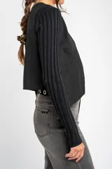 Chaleco negro con escote en V y cierre frontal con botones.