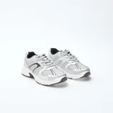 Zapatillas de running color gris metalizado con paneles de malla transpirable, cordones al tono y suela blanca con detalles en negro.