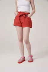 Short color rojo coral con lazo en la cintura y bolsillos delanteros.