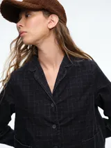 Chaqueta de corte recto y silueta cómoda, con cierre frontal de botones y bolsillos delanteros. Presenta un diseño estampado con efecto tie-dye en tonos negro y blanco.