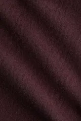 Top de punto fino levemente cepillado, con cuello alto y mangas largas. Presenta pinzas en la cintura para un efecto entallado y cierre con botones en la parte posterior.