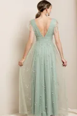 Vestido largo de fiesta color verde agua, con escote en V profundo y mangas cortas con volados. Confeccionado en tul con bordado de estrellas brillantes, presenta una cintura entallada y falda fluida con tajo frontal.