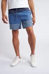 Short de baño con cintura elástica y cordón ajustable, confeccionado en tela ligera de secado rápido. Presenta un estampado botánico integral en tonos amarillos, blancos y azules, con dos bolsillos delanteros y uno posterior.