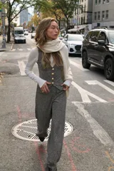 Pantalón de tiro medio, pierna ancha, confeccionado en tejido texturado de color claro con hilo metalizado. Presenta falsos bolsillos delanteros con botones metálicos dorados.