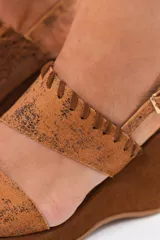 Sandalia de taco chino y plataforma forrada, confeccionada 100% en cuero color tostado con acabado metalizado texturizado en la capellada y detalles de costuras artesanales. Cuenta con doble tira superior y tira trasera ajustable con hebilla metálica.