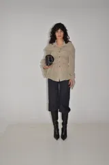 Camisa de gasa fina en tono beige con bordado de lentejuelas, cuello clásico, cierre frontal de botones y mangas largas con puños abotonados.