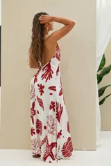 Vestido largo blanco con estampado de motivos marinos en color rojo, escote en V pronunciado y tirantes finos tipo halter.