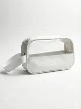 Kit de accesorios para el cabello que incluye un neceser transparente con borde blanco, dos scrunchies (uno negro con perlas y uno beige), dos clips livianos, una pinza dorada, un peine protector para desenredar y un peine para abrir ondas y rulos.