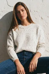 Sweater de punto con diseño jaspeado, cuello redondo y corte oversize. Presenta costuras visibles en los hombros y puños acanalados.