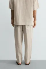 Pantalón relaxed fit de lino color negro, con cintura elástica ajustable con cordón y bolsillos frontales.