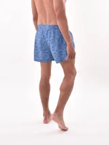 Short de baño blanco con estampado de hojas en tonos azules y rosados, cintura elástica con cordón ajustable.