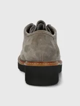 Zapato acordonado Hush Puppies modelo Renovo, confeccionado en descarne color gris. Presenta un diseño robusto con suela gruesa de EVA, costuras visibles en el borde y ojales metálicos para los cordones.