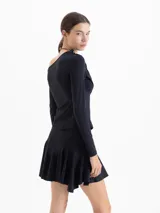 Top de manga larga color violeta, con diseño asimétrico de un solo hombro y detalle de drapeado frontal. Confeccionado en tejido de punto con acabado brillante.