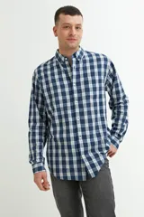 Camisa de hombre a cuadros azules y blancos, de manga larga y corte clásico. Confeccionada en algodón.