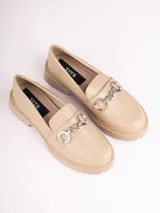 Mocasines color beige con suela track y detalle de cadena plateada.