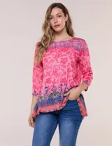 Remera evasé de manga tres cuartos y escote bote, confeccionada en rayón elastizado de color rosado con textura flameada y estampado floral en tonos fucsia y azul.