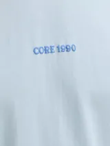 Musculosa celeste de corte holgado y cuello redondo, confeccionada en algodón. Presenta un pequeño estampado gráfico frontal con texto.