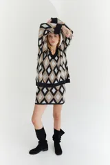 Sweater oversize con cuello en V y estampado de rombos en tonos lila, rosa y rojo. Tejido de lana artesanal.