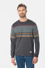 Remera de manga larga con cuello redondo, confeccionada en tejido de algodón y poliéster. Presenta un diseño de franjas horizontales en tonos gris, bordó y ocre sobre una base gris oscuro, con puños ajustados y etiqueta decorativa en el ruedo.