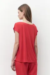 Blusa de satén con estampado floral bicolor en tonos rojo y rosado, de corte recto, cuello redondo y mangas cortas.