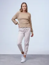 Buzo color beige de tejido combinado con mangas largas caladas y cuello redondo.