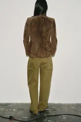 Blazer de ante color marrón, con cuello solapa, hombreras, manga larga y cierre frontal cruzado con botones. Cuenta con bolsillos delanteros de doble vivo.