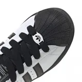 Championes Adidas Superstar de diseño clásico con exterior de cuero blanco, icónicas tres tiras laterales en negro, puntera de goma reforzada y suela de plataforma en color negro.