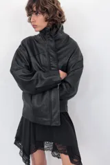 Cazadora de corte oversize confeccionada en 100% piel. Presenta cuello subido, manga larga con hombro caído y cierre frontal mediante cremallera y botones a presión ocultos bajo una solapa. Incluye bolsillos laterales ocultos en las costuras y forro interior.