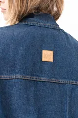 Campera de jean azul de silueta relajada, con cuello clásico, cierre frontal con cremallera metálica y bolsillos laterales.