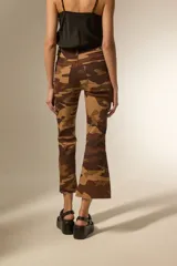 Pantalon jean de corte flare y tiro alto con estampado camuflado en tonos marrones.