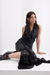 Vestido largo negro de crepe elástico con brillo, sin mangas, con escote drapeado y corte recto y fluido.