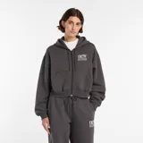 Campera con cierre frontal completo y capucha, confeccionada en tejido polar color gris oscuro. Presenta un diseño de corte holgado con bolsillos frontales tipo canguro y el logo de la marca estampado en el pecho.