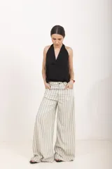 Pantalón de lino blanco de tiro alto, corte wide leg y bolsillos delanteros tipo ojal.