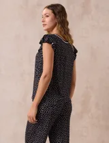 Conjunto de pijama marca René Rofé, compuesto por una remera de escote en V con botones y un pantalón capri con cintura elastizada, ambos en tejido soft estampado con motivos florales en tonos celeste y blanco.