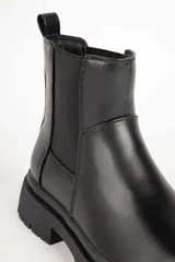 Bota Chelsea marrón de símil cuero con elásticos laterales negros y suela track negra.