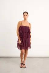 Vestido corto bordó de chifón con múltiples volados horizontales en capas, breteles finos adornados con cuentas y escote recto.
