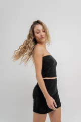 Top strapless confeccionado en tejido elástico con apliques de strass que aportan un efecto brillante tipo glitter. Silueta al cuerpo, calce cómodo y sin cierre.