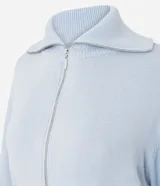 Campera cropped de tricot color blanco off-white, confeccionada en algodón con textura acanalada. Presenta cuello amplio con cierre metálico frontal, mangas largas con puños acanalados y cintura marcada con banda ancha.
