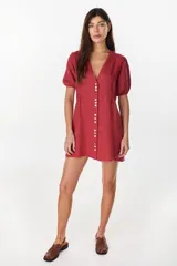 Vestido corto negro de lino italiano, con escote en V, mangas cortas abullonadas y cierre frontal de botones con cintura entallada y tablas.