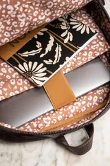 Mochila marrón con estampado de piel de cocodrilo, con cierre superior y bolsillo frontal con cierre.