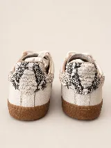 Championes de cuero con diseño urbano, combinando paneles de cuero texturizado en color crema con detalles en gamuza color tostado en la puntera. Presentan cordones al tono, suela de goma y un monograma bordado en el lateral, con un detalle de estampado animal print en el talón.