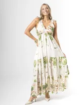 Vestido largo confeccionado en mezcla de tencel y lino, con fondo off white y estampado floral en tonos rosados, rojos y verdes. Cuenta con escote en V pronunciado, breteles anchos ajustables con lazos en los hombros, corte bajo el busto y falda amplia con volados escalonados.
