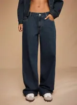 Jean de tiro medio con calce wide leg y pierna amplia, confeccionado en denim rígido de color azul oscuro.
