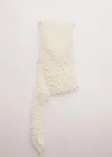 Blusa blanca sin mangas, con diseño asimétrico y textura de flecos tridimensionales en toda la superficie.