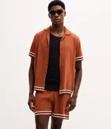 Bermuda masculina de jacquard color marrón tostado, con cintura elástica, bolsillos y detalle de franjas blancas en los dobladillos.