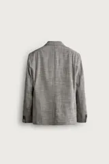 Blazer regular fit de Zara, confeccionada en tejido con mezcla de lana y algodón con diseño de cuadros grises. Cuenta con solapas de pico, doble botonadura cruzada, bolsillos con solapa en la cadera y bolsillo de vivo en el pecho.