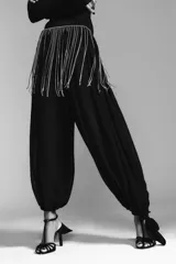 Cinturón metálico plateado con flecos de cadenas finas y brillantes. Cierre con mosquetón.