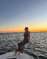 Vestido largo de tejido de punto calado color crema, con escote halter y espalda descubierta.