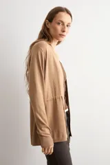Ruana negra de tejido de punto, con mangas largas y cordón ajustable en la cintura.