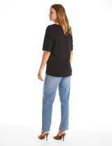 Blusa de silueta fluida con escote en V, manga japonesa corta y costura central vertical en el frente. Confeccionada en tejido de punto con acabado mate, presenta un diseño con largo asimétrico, siendo más larga en la espalda.